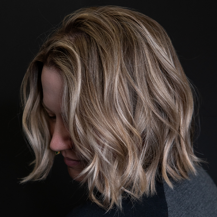 Soft, lived-in blonde balayage with cool sandy brown tones, pale ash highlights, and a seamlessly blended shadow root.