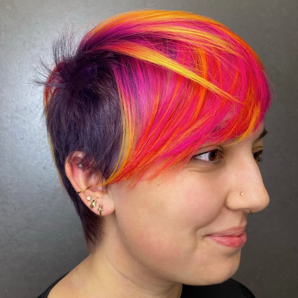 woman with bright pink orange and yellow hair in salon