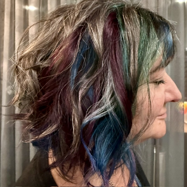 Middle-aged woman with beautiful burgundy and silver colored hair in salon