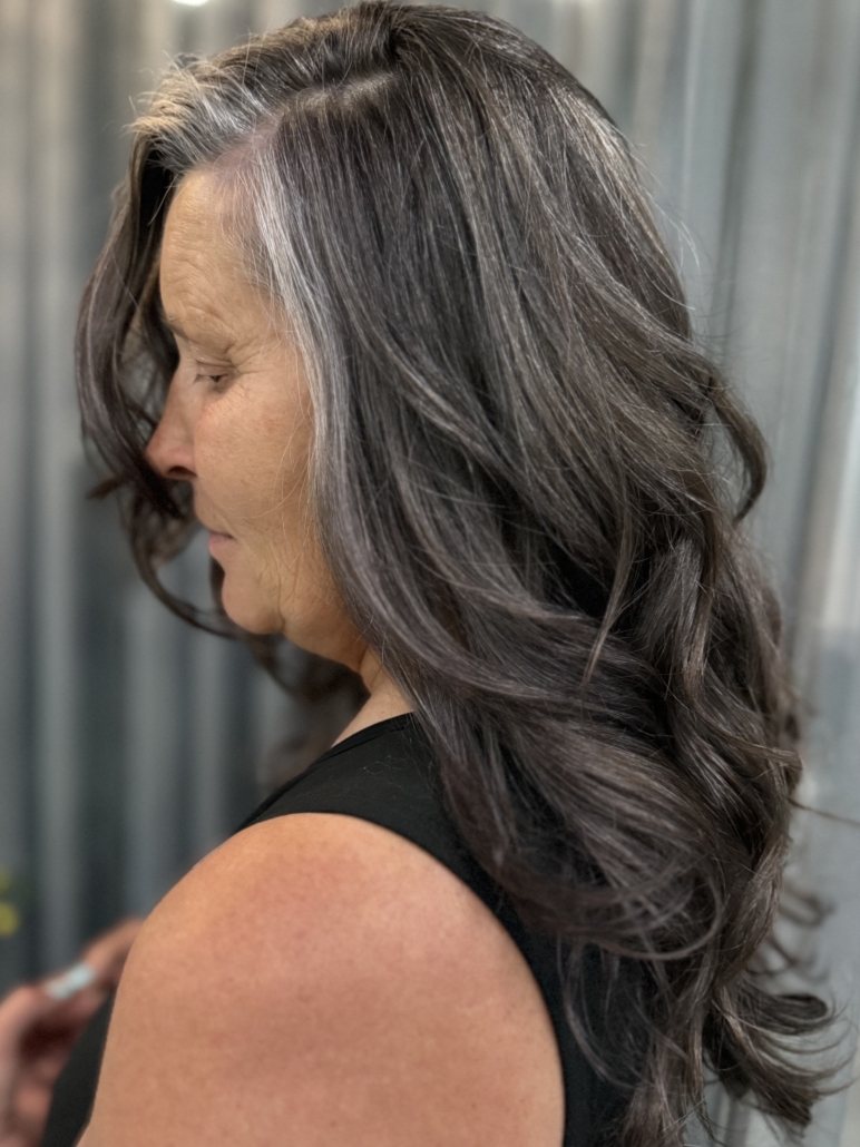 Middle-aged woman with perfectly blended grey colored hair in salon