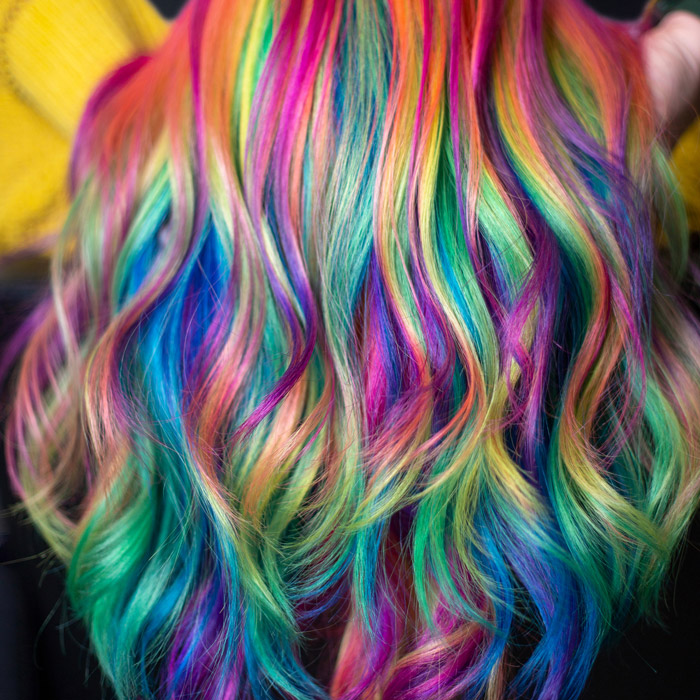 woman with wavy hair dyed bright colors in salon