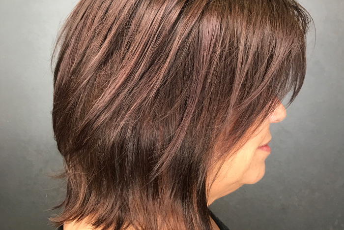 Middle-aged woman with beautiful brown colored hair in salon