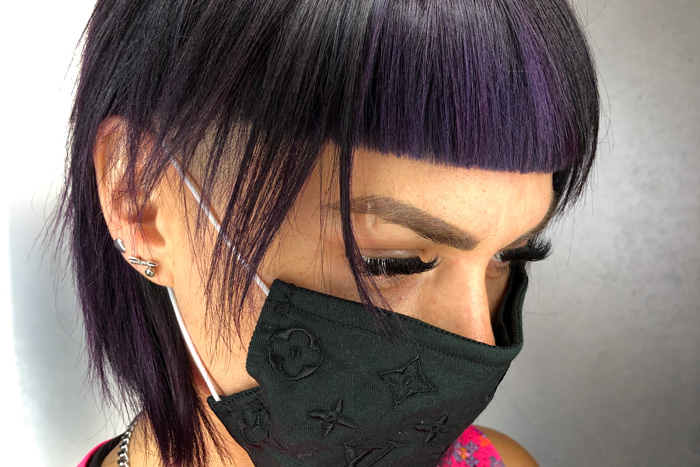 young woman with black and purple colored hair in salon