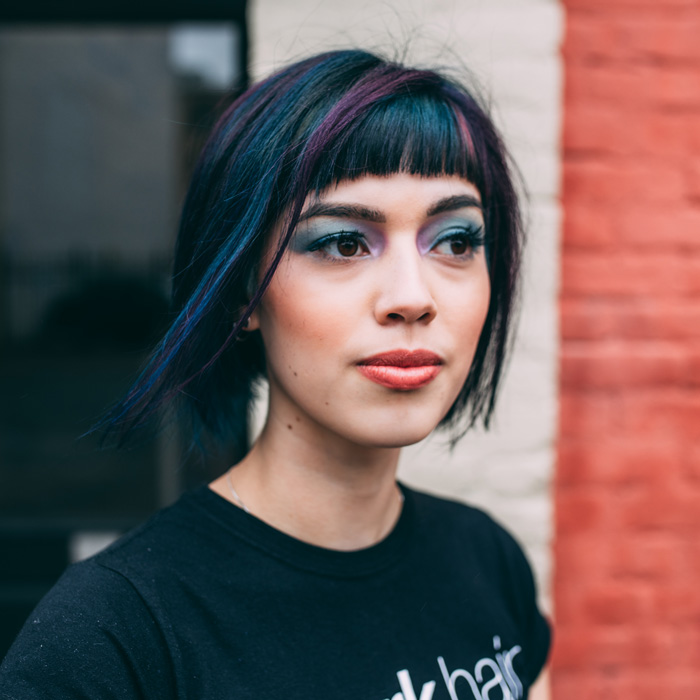young woman with black and purple colored hair outside of salon