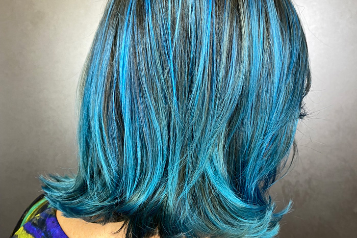 woman with teal and blue coloured hair in salon