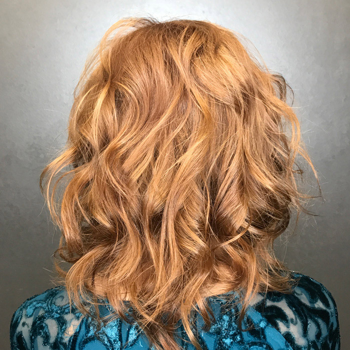 woman with curly and texture blonde hair goldwell elumen