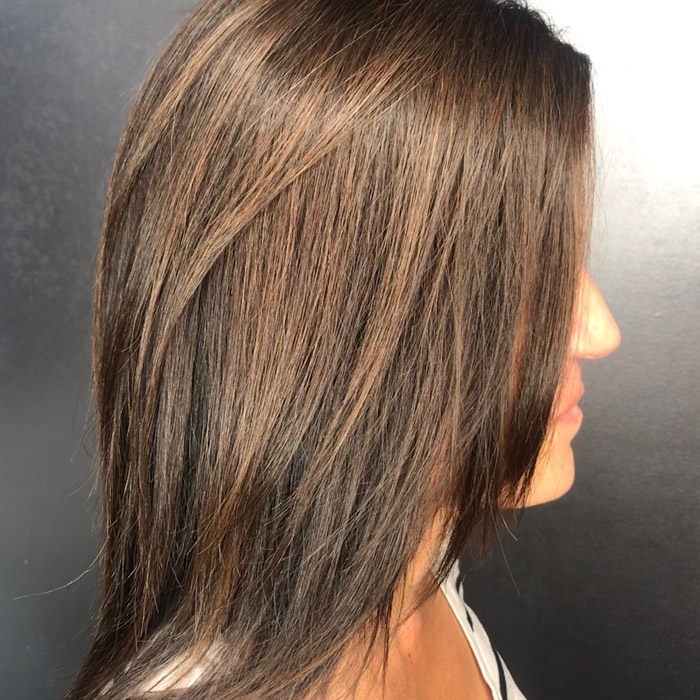 young woman with beautiful brown colored hair in salon