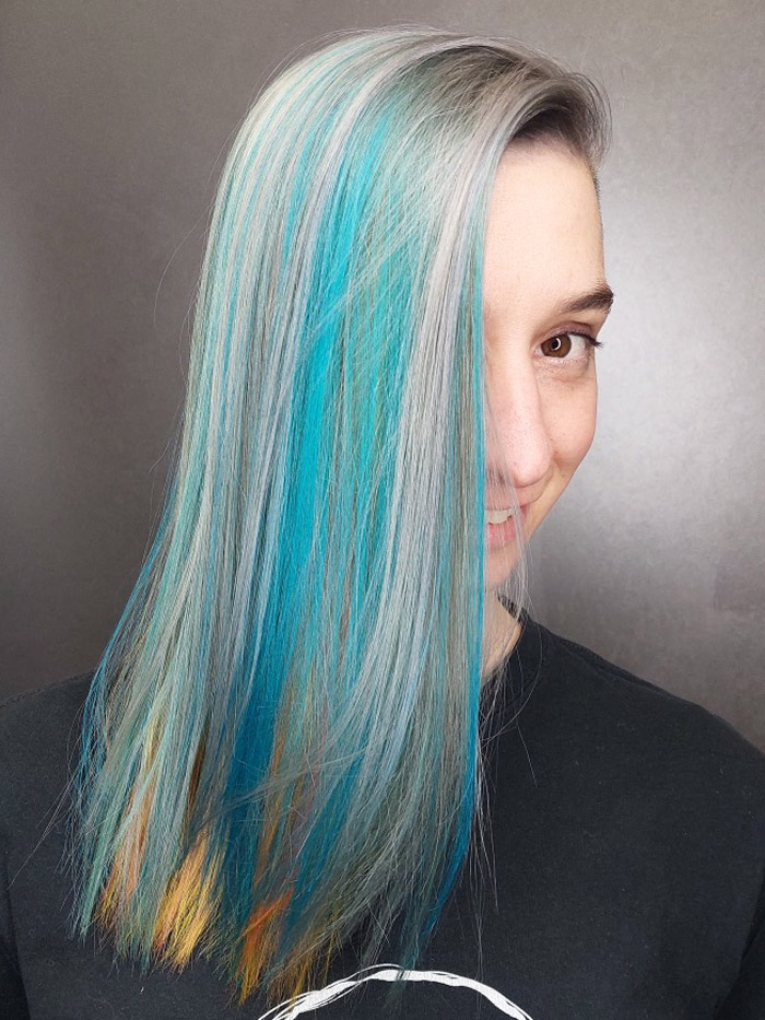 young woman with grey and blue and yellow hair in salon goldwell elumen